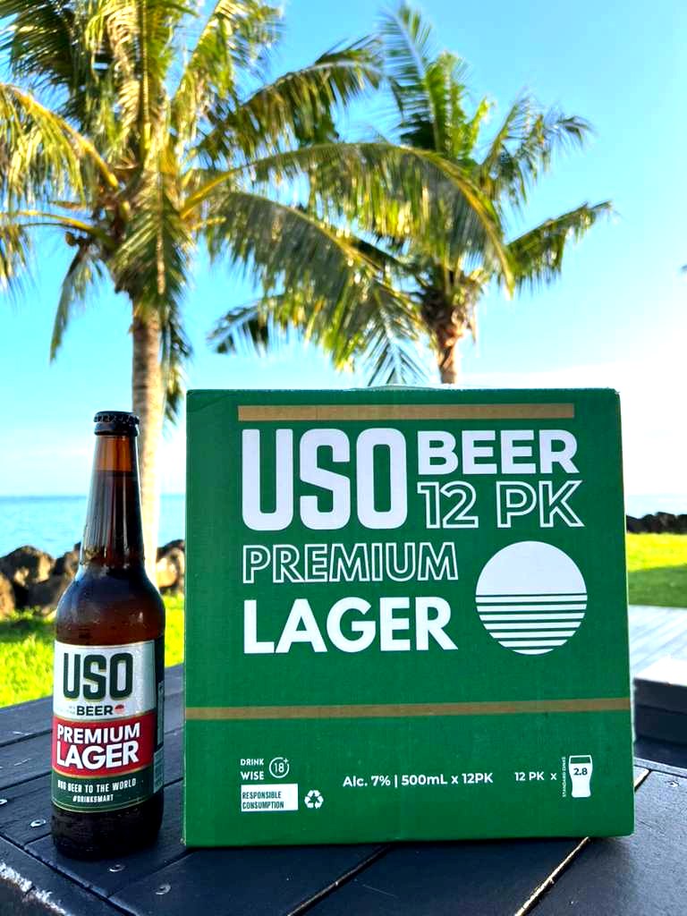 USO Premium Lager bottle and green 12-pack box poolside